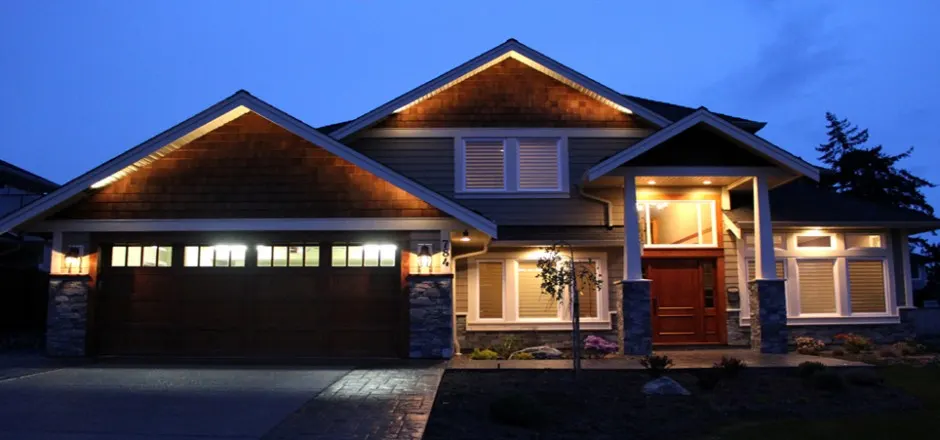 New custom home at twilight with warm exterior lighting