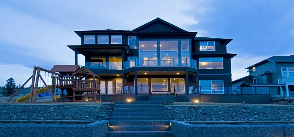 Three-storey custom home with view decks at dusk